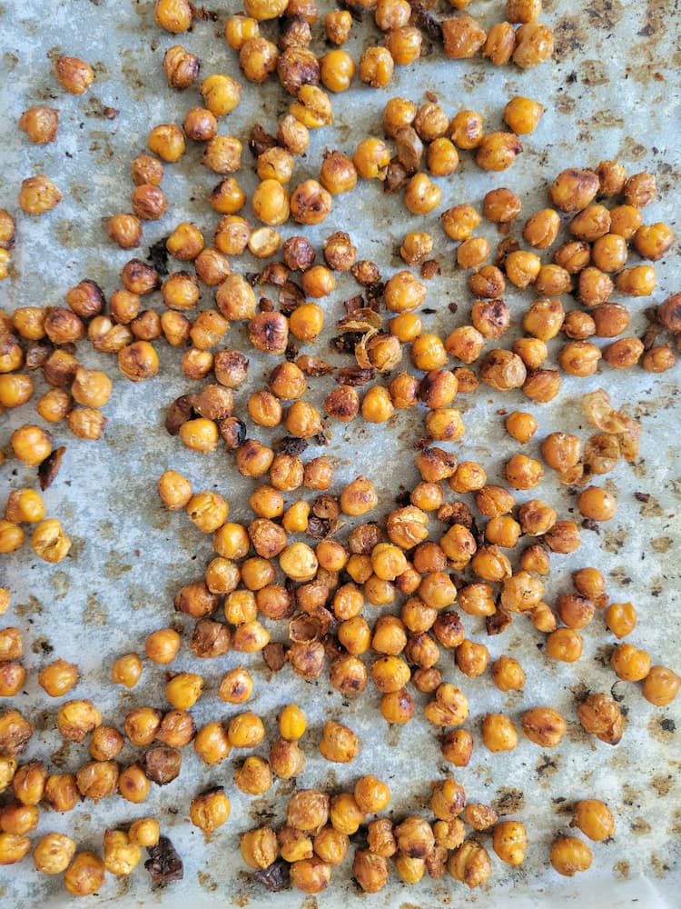 close up of roasted chickpeas on a parchment lined sheet pan