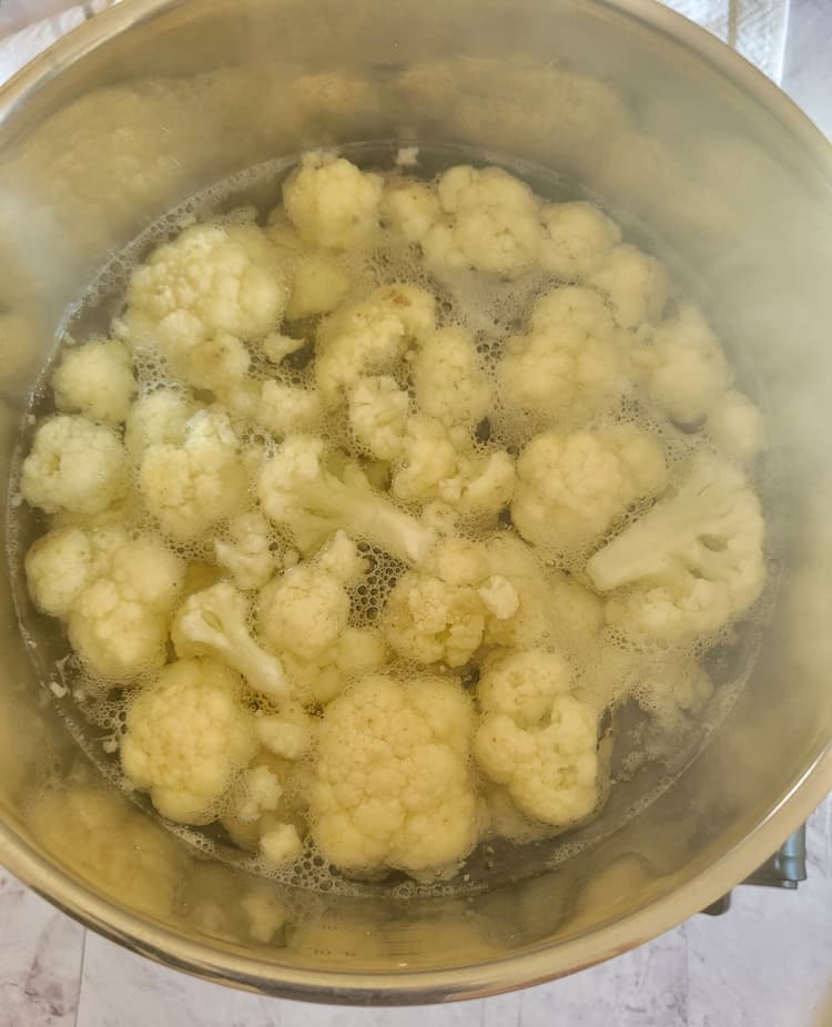 cauliflower florets boiling in a pot of water