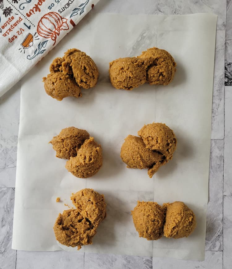 dollops of raw cookie dough on a piece of parchment paper