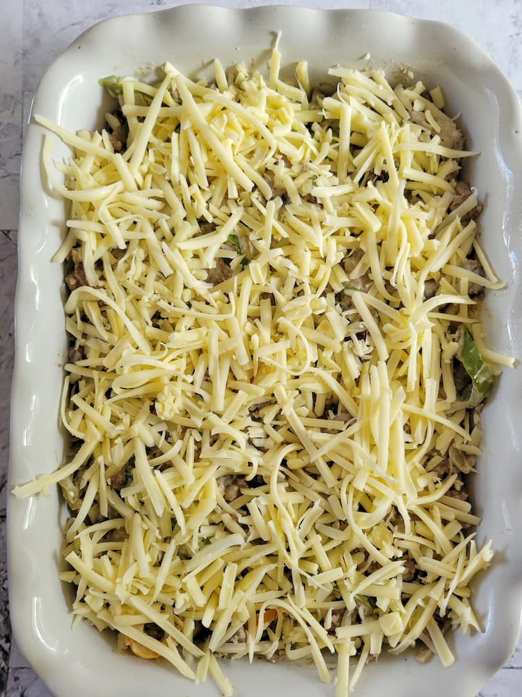 unbaked philly cheesesteak casserole in a dish with unmelted mozzarella cheese on top