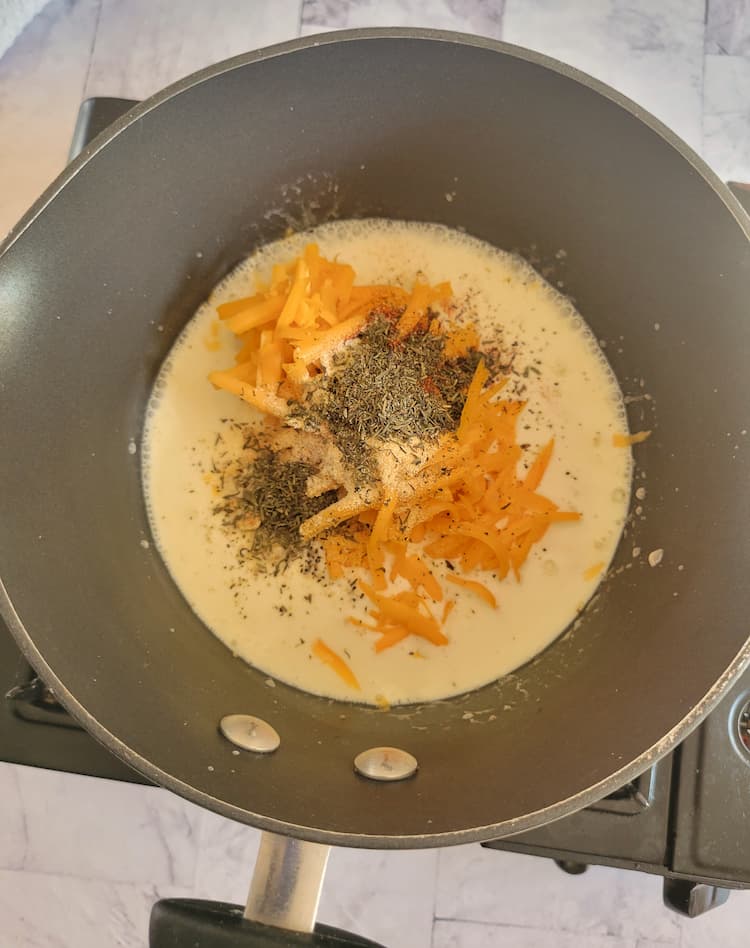 small pot of heavy cream, spices and cheddar cheese