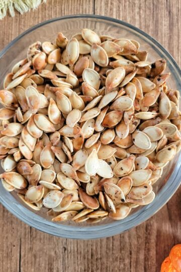 close up of a bowl of whole roasted pumpkin seeds
