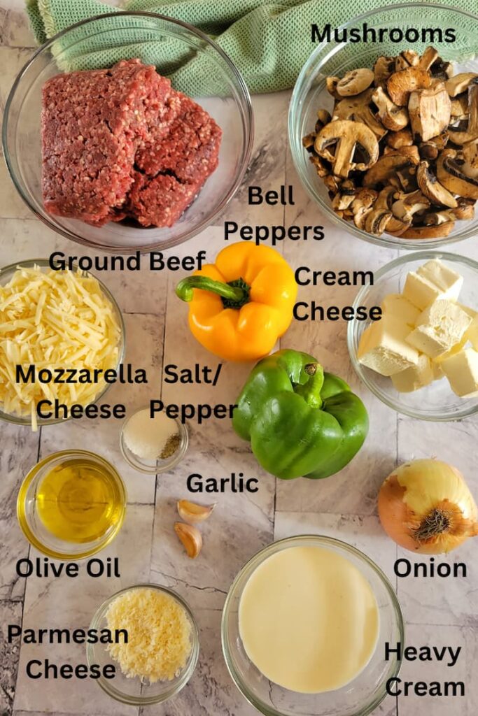 ingredients for philly cheesesteak casserole - ground beef, bell peppers, mushrooms, mozzarella cheese, salt and pepper, cream cheese, onion, heavy cream, garlic, olive oil, parmesan cheese