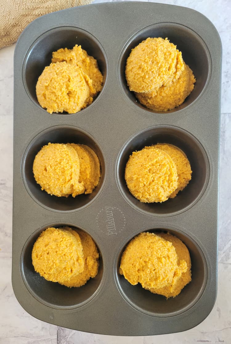 6 cup muffin tin with scoops of fresh batter in each