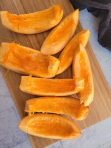 raw pumpkin wedges on a cutting board