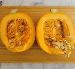 halved and split open sugar pie pumpkin exposing the flesh and seeds