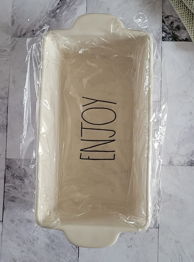 plastic wrap lined loaf pan that says 'enjoy'