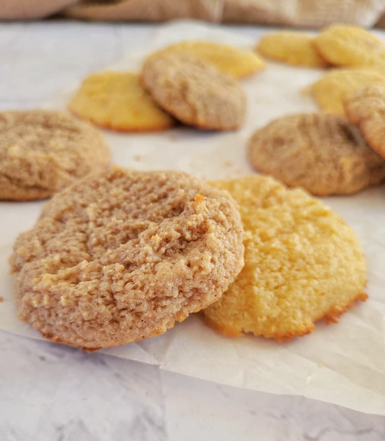 two different kinds of cookies in piles on parchment paper