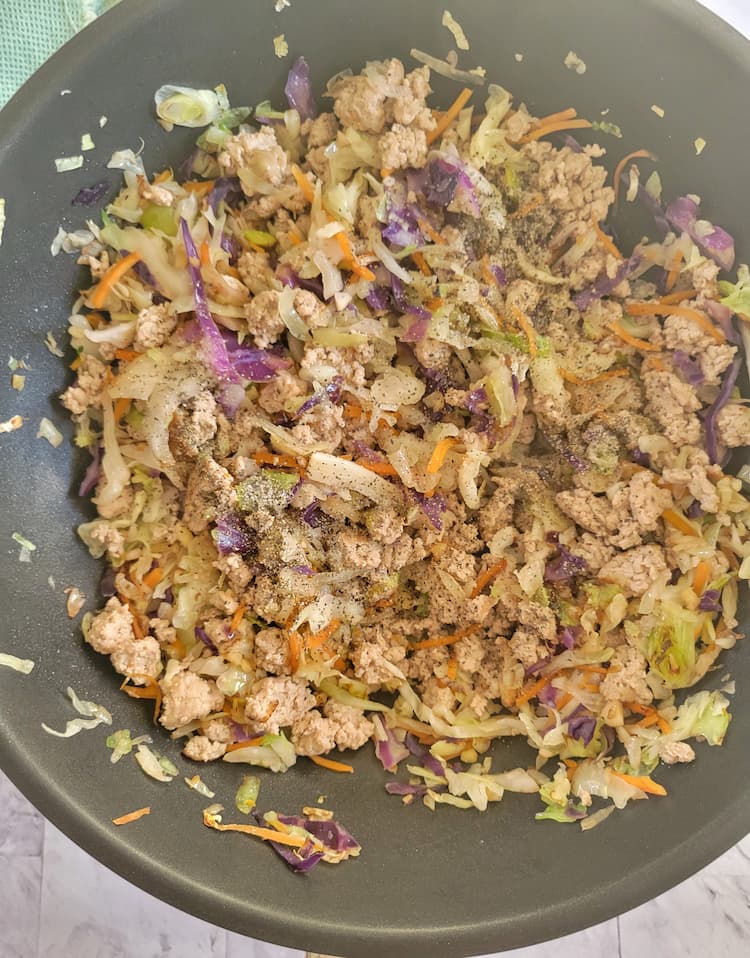 skillet with cooked ground turkey and coleslaw