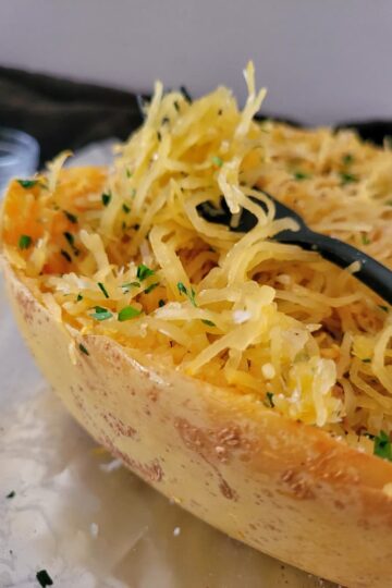 side view of cooked spaghetti squash garnished with parsley