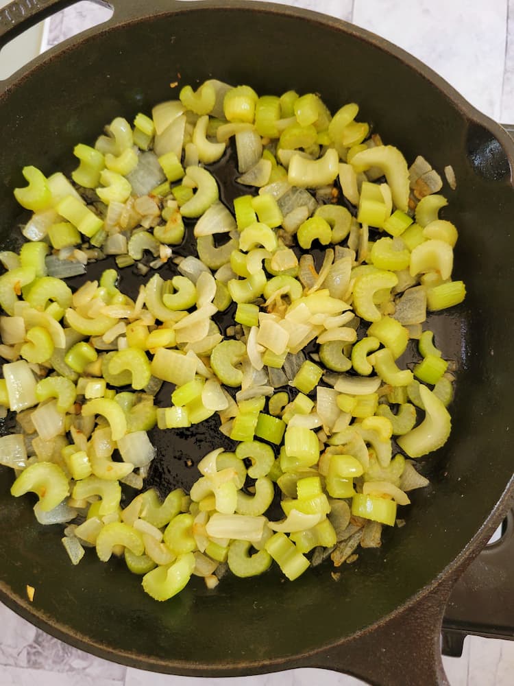 cast iron skillet with cooked diced celery and white onion