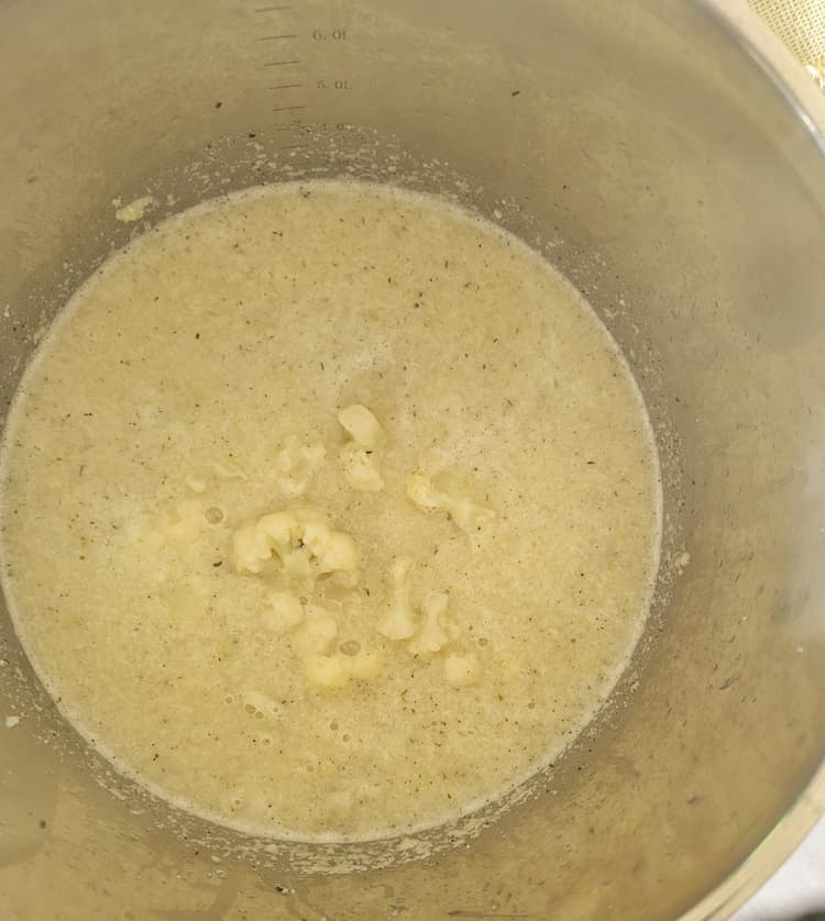 pot of cauliflower soup with some florets inside
