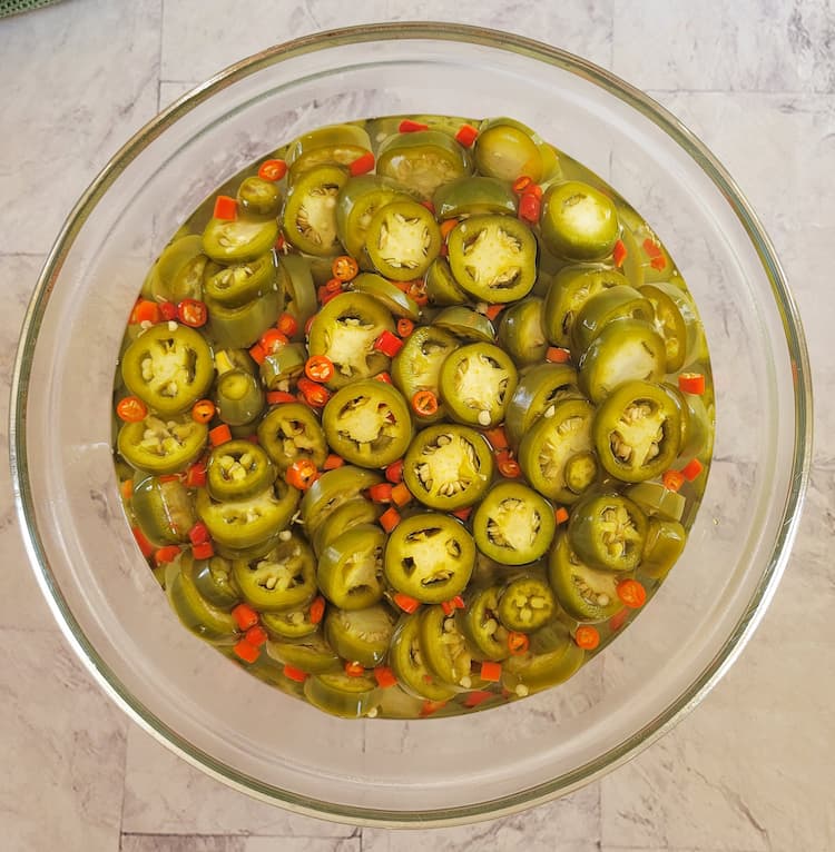 bowl of sliced jalapeños and thai red chilies in vinegar