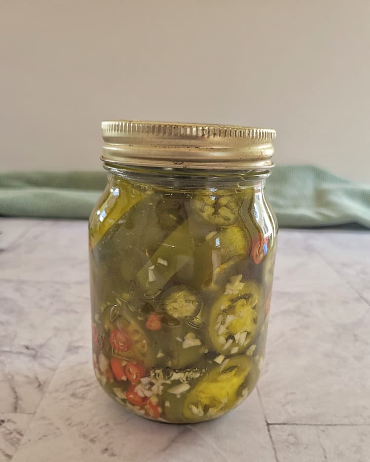 jar of sliced jalapeños, thai red chilies and minced garlic submerged in olive oil
