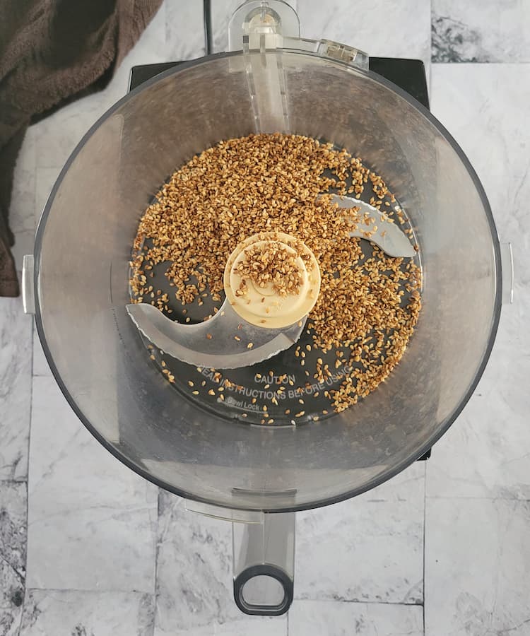 base of a food processor with roasted sesame seeds