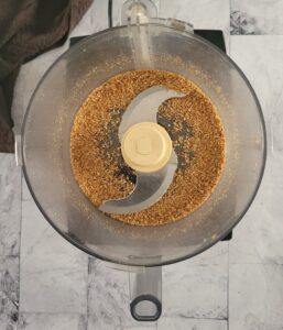 base of a food processor with ground up roasted sesame seeds