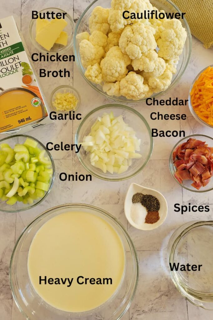 ingredients for keto cauliflower soup - cauliflower, bacon, cheddar cheese, heavy cream, spices, garlic, celery, onion, chicken broth, butter, water