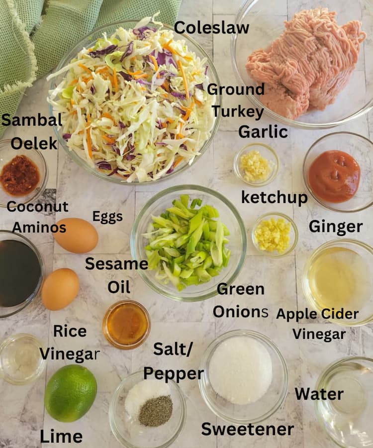 ingredients for keto egg roll in a bowl - coleslaw, ground turkey, sambal oelek, eggs, coconut aminos, ketchup, garlic, ginger, rice vinegar, apple cider vinegar, water, sweetener, green onions, salt/pepper, sesame oil, lime