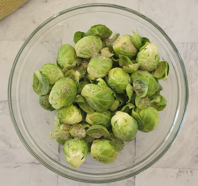 brussels sprouts seasoned with salt and pepper in a bowl