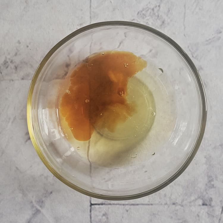 small glass bowl of vanilla extract and egg white