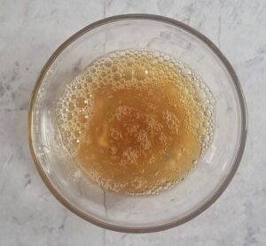 small white bowl of brown frothy liquid