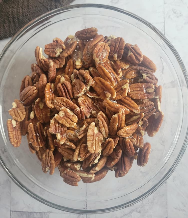 bowl of whole pecans with liquid over top