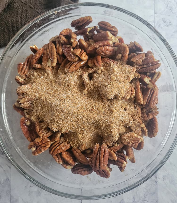 bowl of whole pecans with cinnamon sugar poured in a pile over top