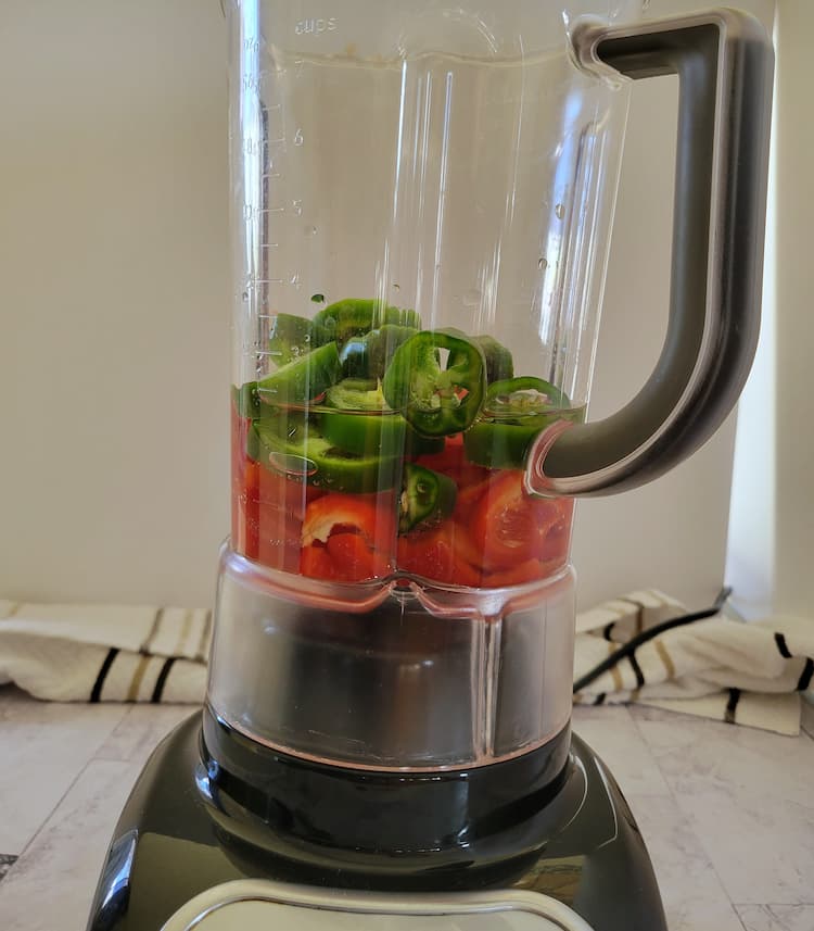 blender with sliced jalapenos and red bell peppers