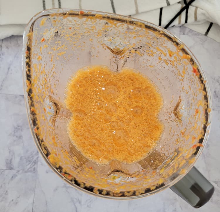 top view of a blender without a lid - orange foamy liquid in the blender