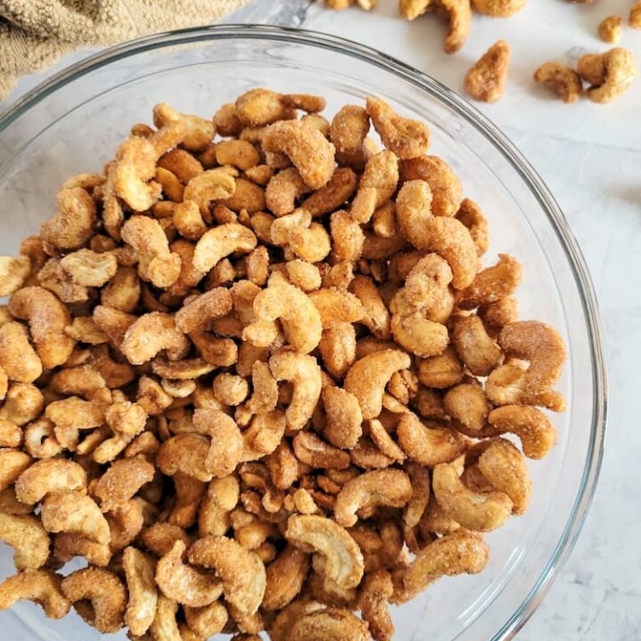 bowl of candied cashews with some in the background