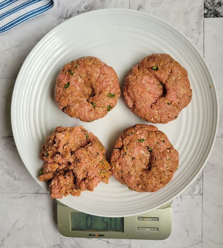plate of raw ground beef patties on a scale