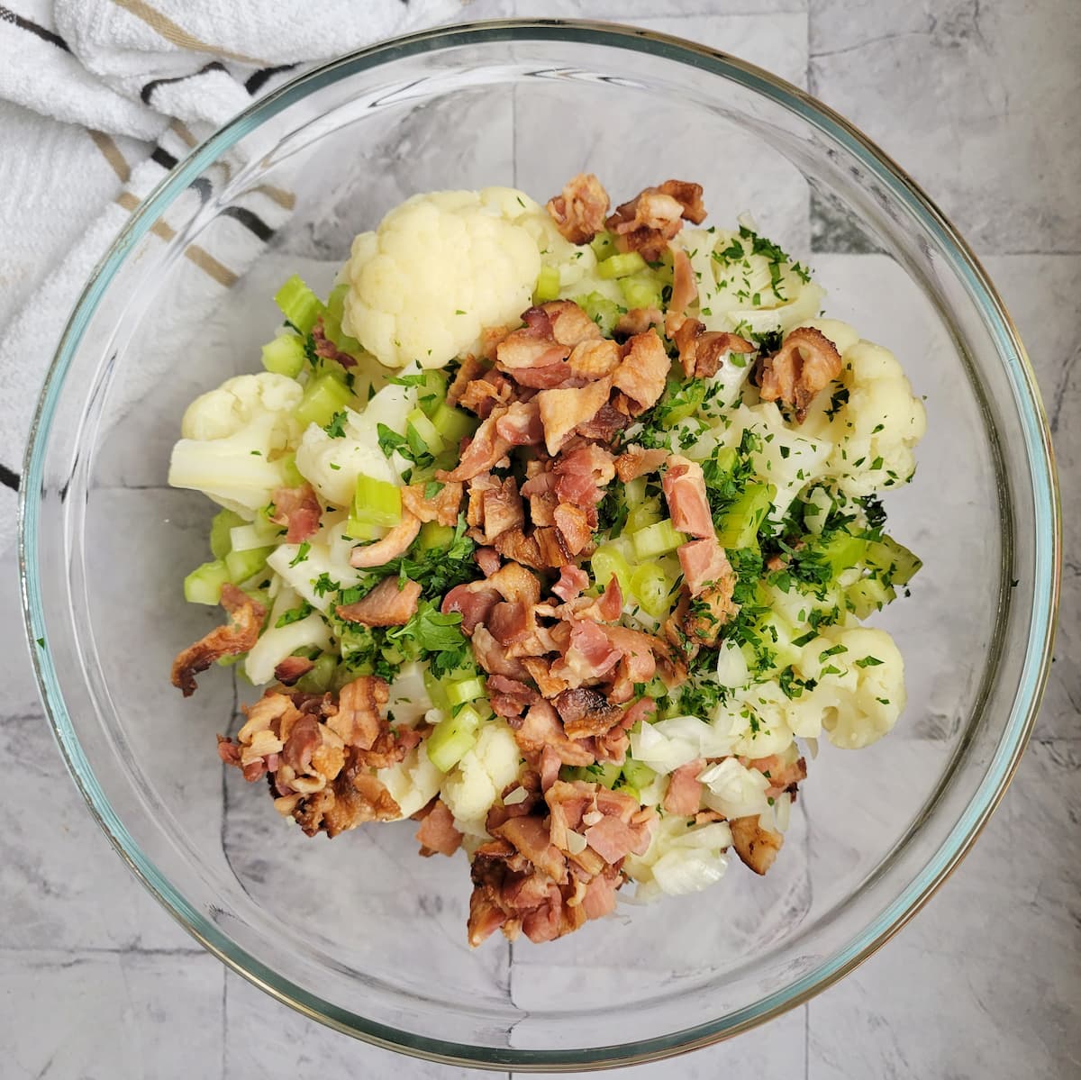 chopped bacon, celery, onions, parsley and cauliflower florets in a bowl