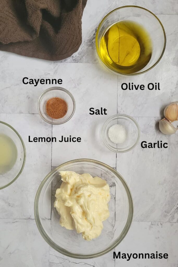 ingredients for aioli recipe - mayonnaise, olive oil, garlic, cayenne, salt, lemon juice