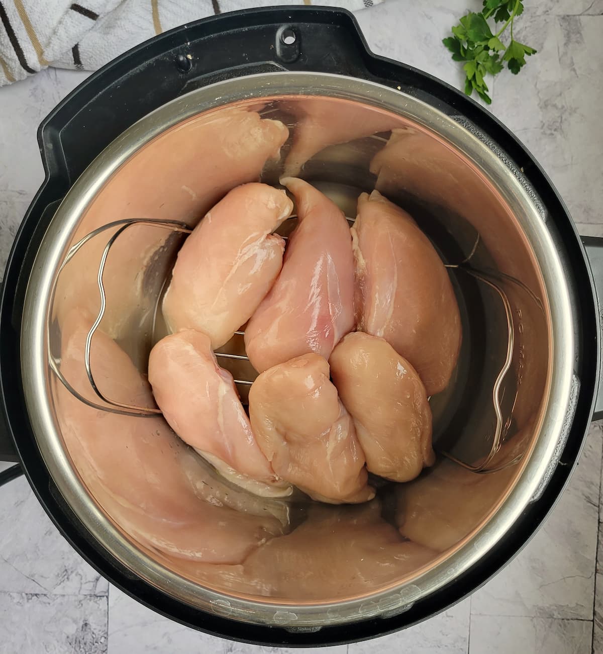 6 raw chicken breasts on the metal trivet in the instant pot