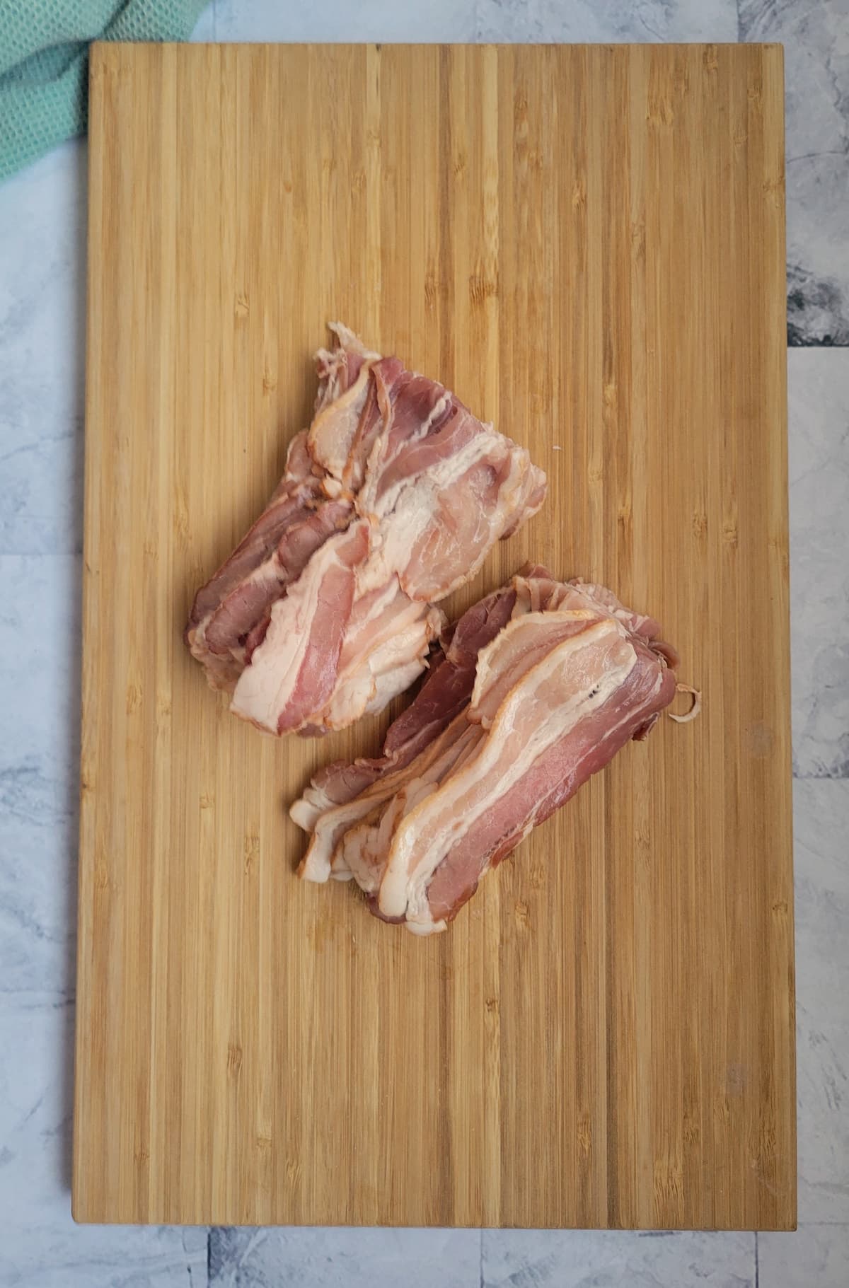 halved bacon strips on a cutting board