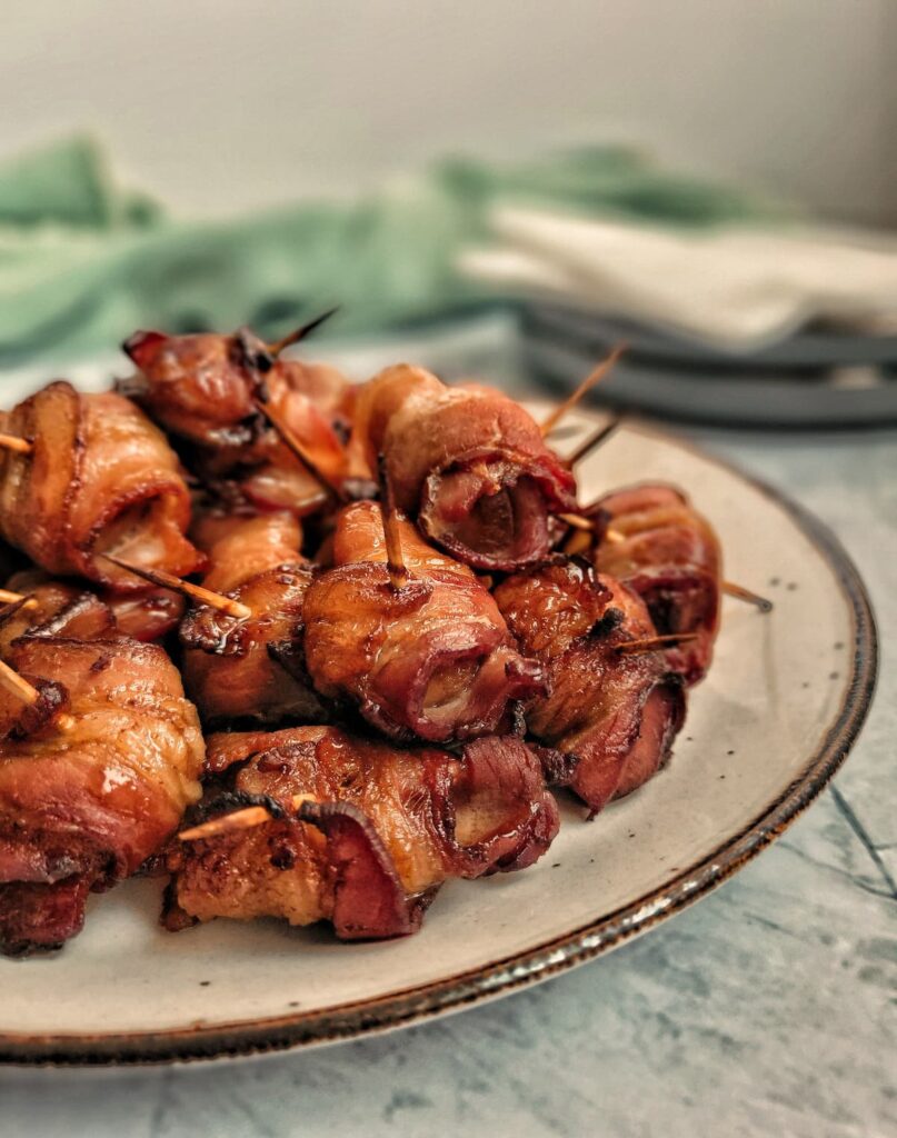 plate full of bacon wrapped water chestnuts with toothpicks in them