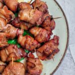 plate full of bacon wrapped water chestnuts with toothpicks in them