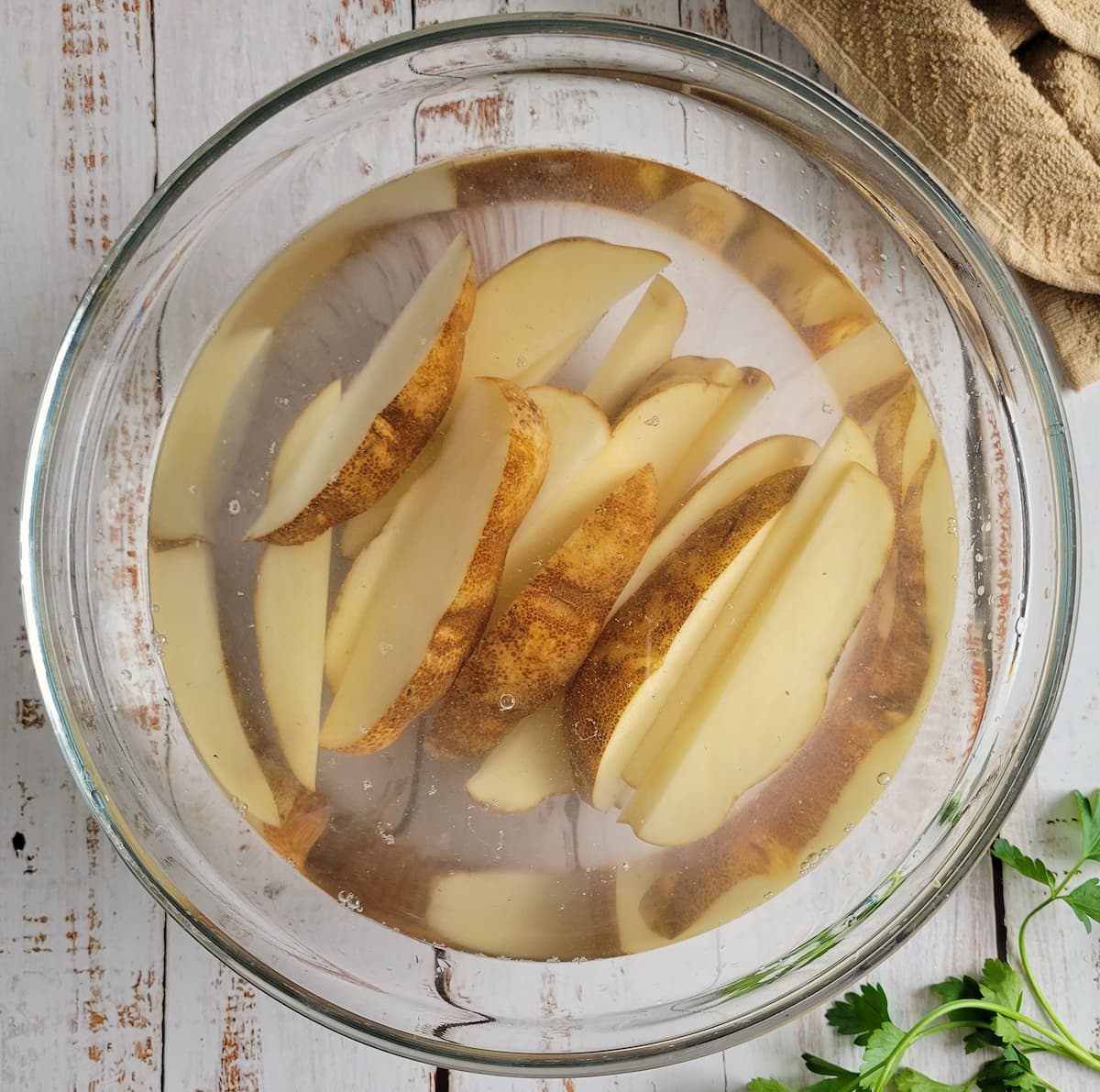 bowl of potato wedges soaking in water
