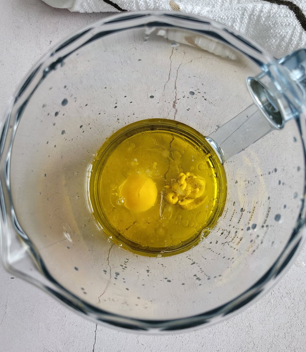 oil, an egg and dijon in a jug