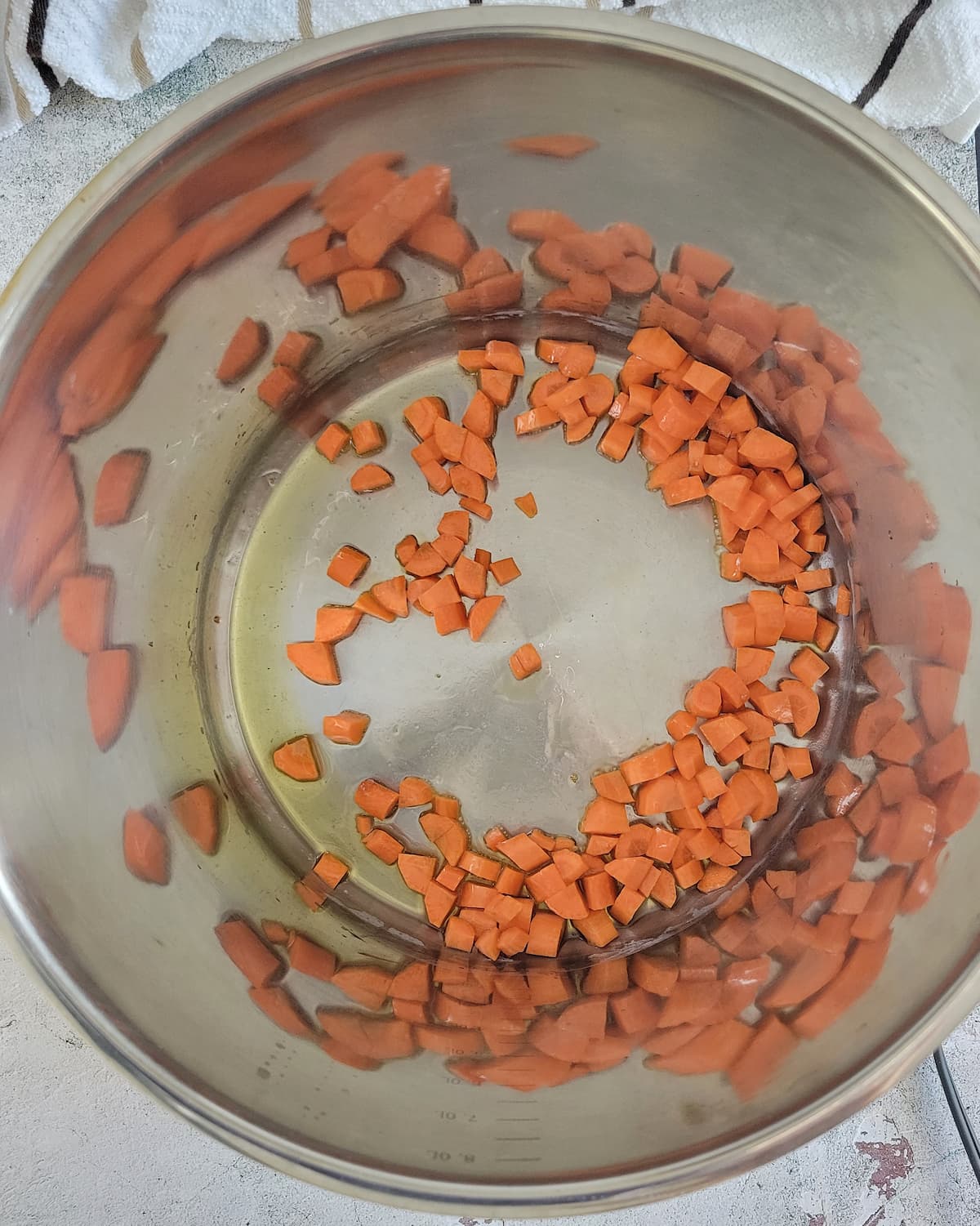 diced carrots sautéeing in oil in a large pot