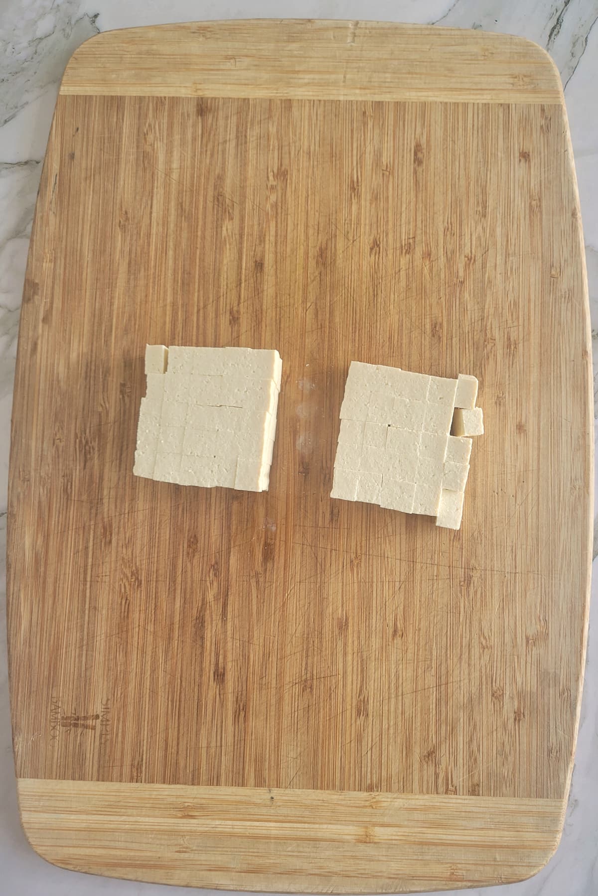 cubed blocks of tofu on a cutting board