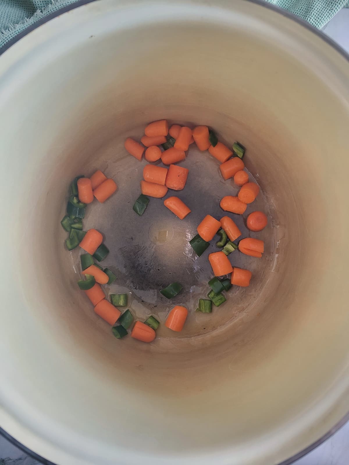 pot with halved baby carrots and diced jalapenos