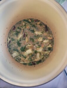 pot with broth, chopped parsley, bok choy and mushrooms