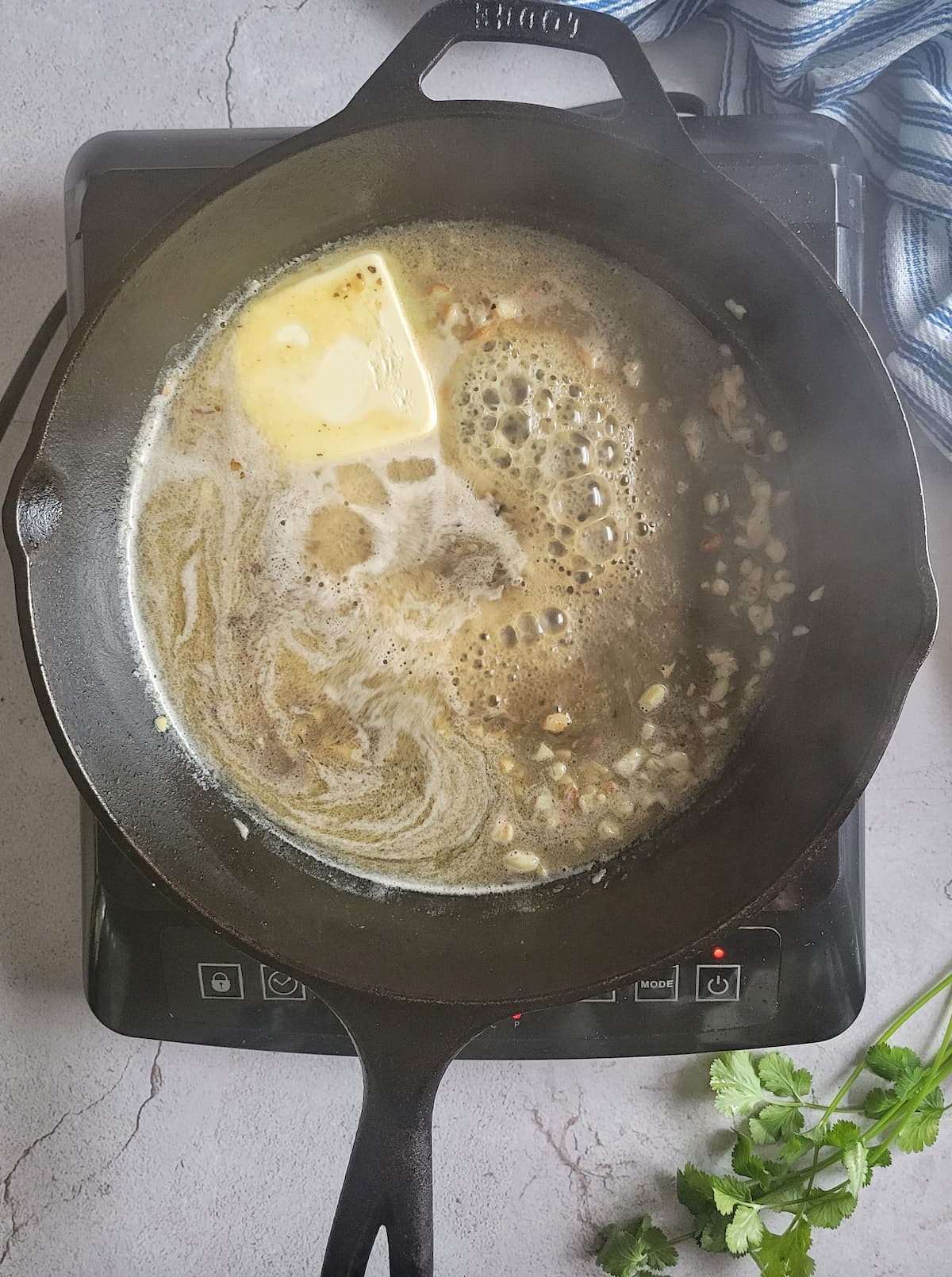 butter melting in a cast iron skillet with minced garlic
