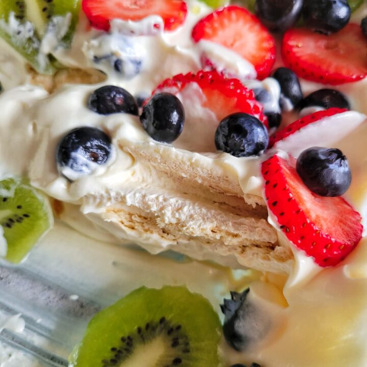 layered whipped cream dessert with fresh sliced kiwi, strawberries and blueberries