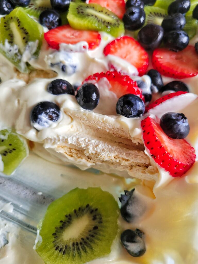 layered whipped cream dessert with fresh sliced kiwi, strawberries and blueberries