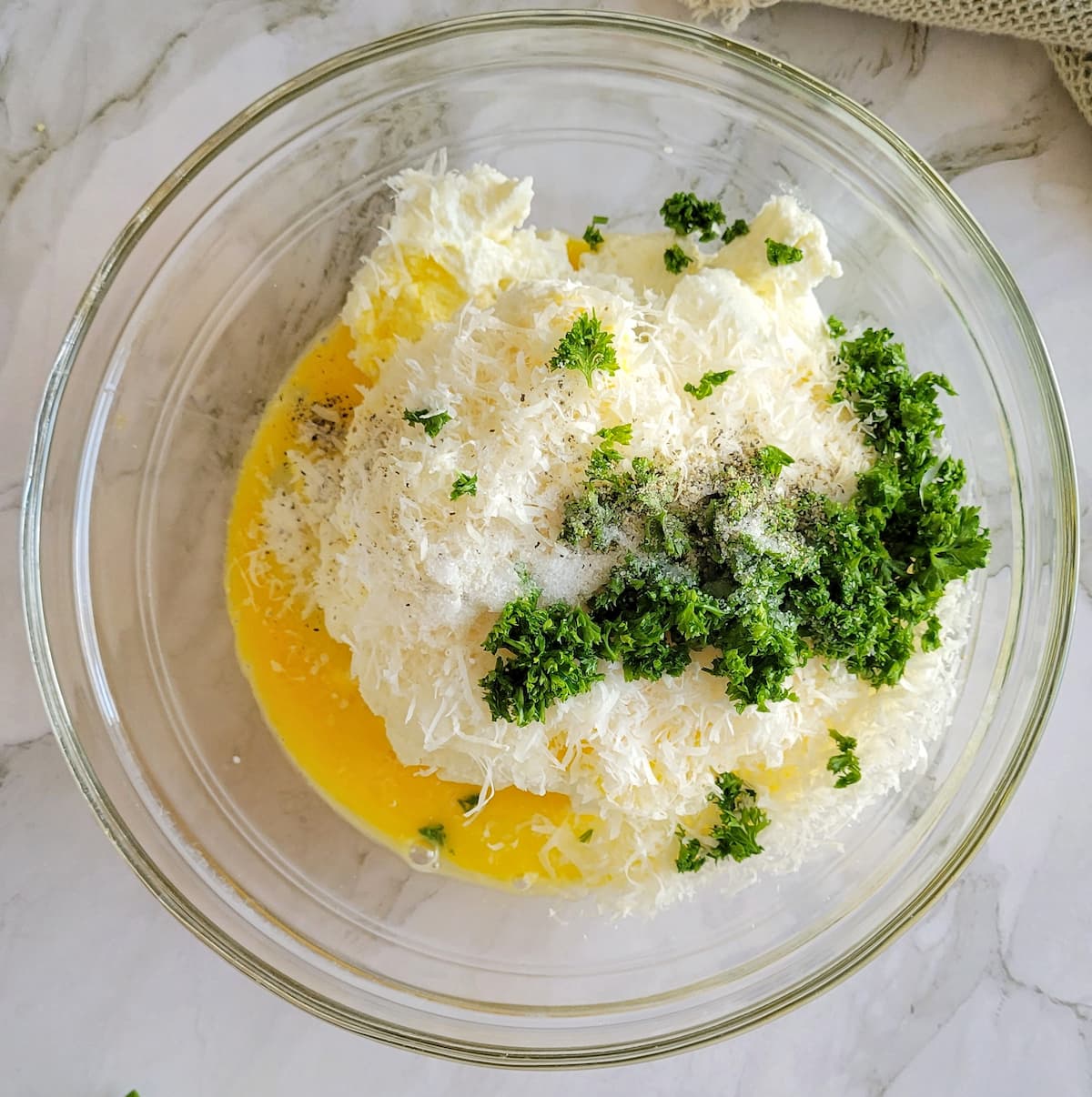 bowl of freshly grated parmesan cheese, chopped parsley, egg, ricotta