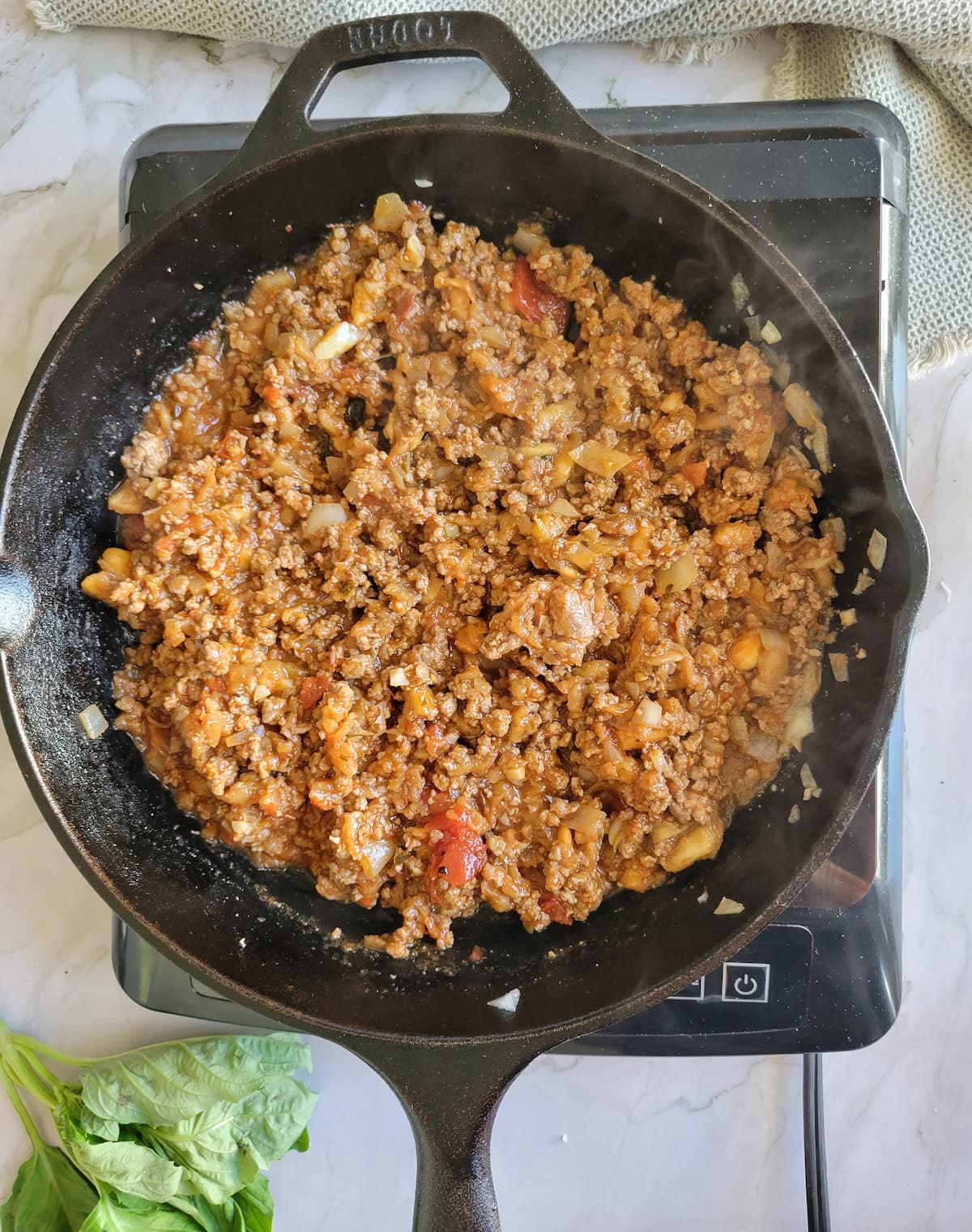 ground beef and tomato sauce in a cast iron skillet