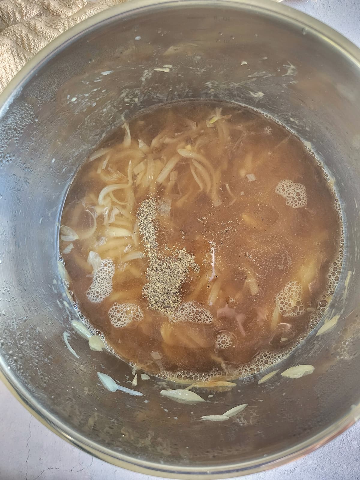 beef broth, spices and sliced onions in a pot