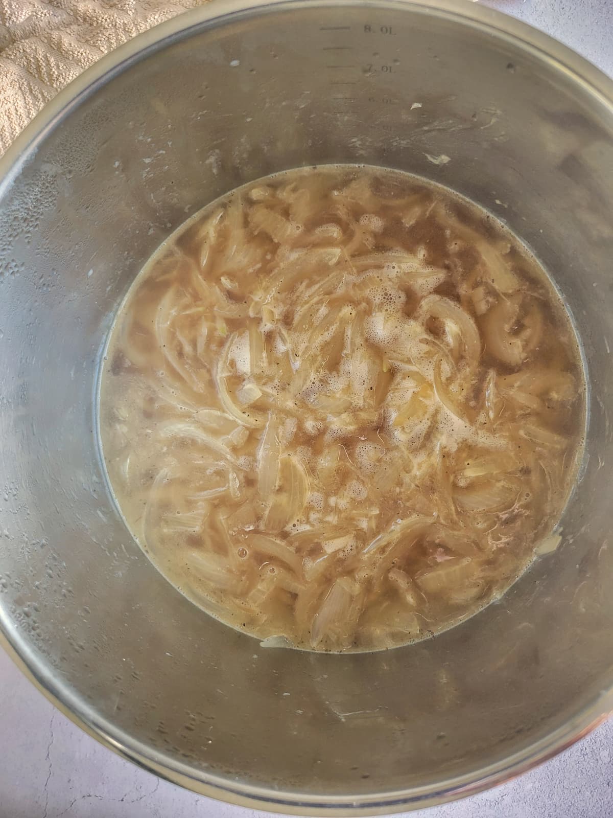 beef broth and sliced onions in a pot